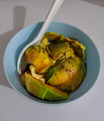 An Avocado with Chocolate Milk served in a light blue bowl with a spoon
