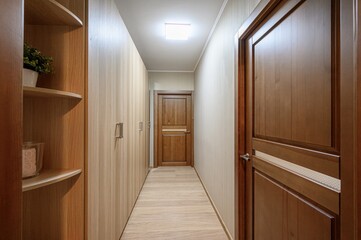 Hallway with wooden doors and closets, lit by a ceiling light