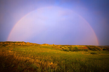 Naklejka premium Beautiful Sunset Rainbow on Open Grassland