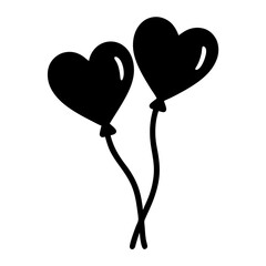 Two black heart shaped balloons floating gracefully in the air together