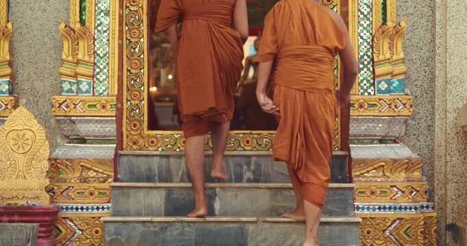 Young Buddhist novices step into a richly decorated temple for the evening chanting ritual, joining senior monks in a traditional act of devotion and community.