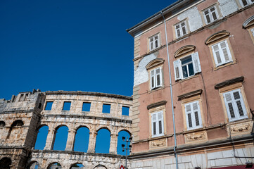 Part of the amphitheater and an older house in Pula, Croatia