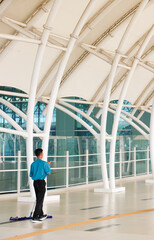 A male airport janitor mopping the floor to maintain the cleanliness of the airport area.