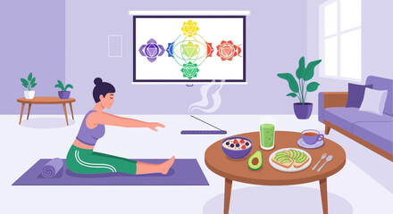 Fototapeta premium Woman practicing yoga at home with a screen displaying chakra symbols and healthy meal preparation