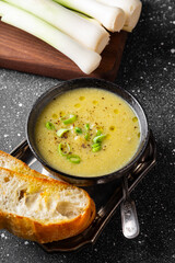 A bowl of leek soup with toasted bread close up vertical photo
