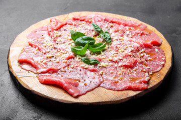 Slices of fresh beef carpaccio with basil and parmesan cheese