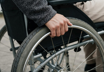 Obraz premium Close-up of an Adult Hand on a Wheelchair Wheel Demonstrating Independent Movement and Accessibility