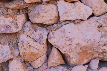 Old natural stone masonry without mortar between the stones, natural background
