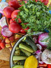 Fresh vegetables and herbs, including tomatoes, onions, cucumbers, parsley and dill, vibrant food background.
