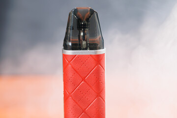 Cigarro electrónico sobre la mesa rodeado de humo 