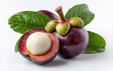 Two mangosteens, one halved revealing its creamy white segments, rest on a white background, accompanied by vibrant green leaves