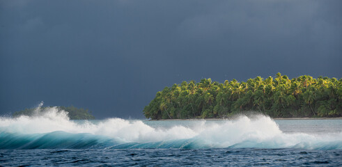 Storm approaching an Island while waves are crashing over the reef barrier