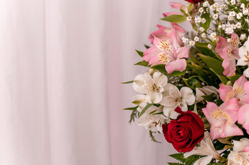 Beautiful arrangement of colorful flowers with curtain in the background