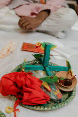 Ceremonial tray with vibrant elements like colorful wooden birds, red fabric, and a small bowl,...