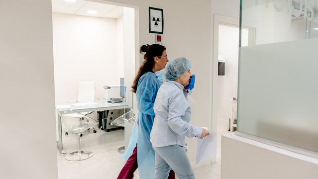 Dental assistant guiding patient to treatment room