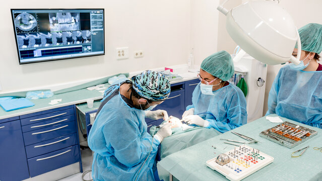 Dental professionals performing implant surgery