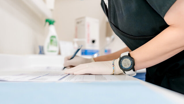 Dental assistant writing patient information in clinic