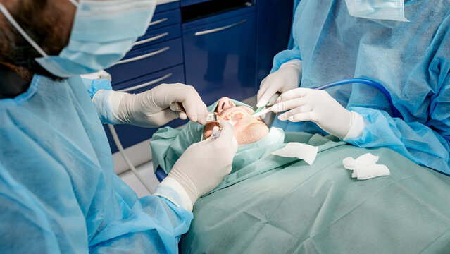 Dental care professionals performing implant surgery