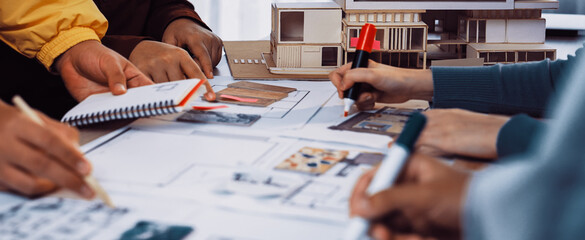 A creative team collaborates in an architectural studio, engaged in hands-on planning and sketching for innovative building designs, showcasing teamwork and professionalism. SACTR