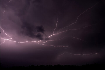 Dramatic lightning storm illuminating night sky