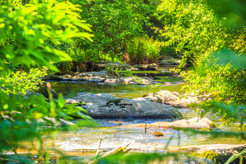 Landscape still shot of the Dure River in Brousse and Villaret in the South of France. Small waterfalls and undergrowth in Occitanie.
