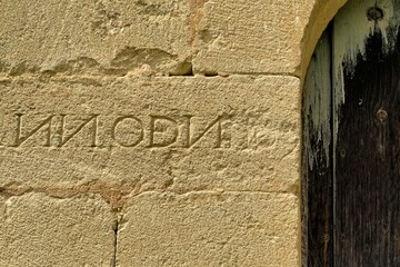Ancient inscription on stone wall of Ermita de la Tida in Villaescusa de las Torres