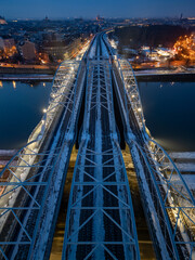 Aerial view of railroad bridge over Vistula river in Krakow, Poland, illuminated in the winter evening