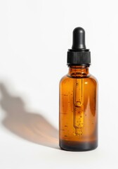 Amber glass dropper bottle with shadow on white
