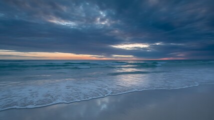 Serene ocean waves at twilight under dramatic clouds beach sunset