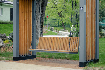 wooden swing on chains in city park