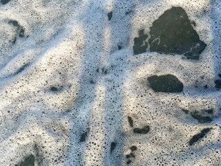 Abstract seafoam texture in a natural style in white and dark colors representing nature and coastal themes with copy space