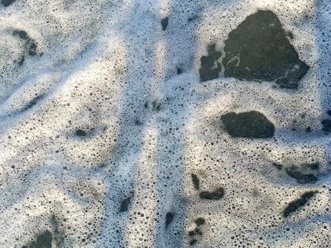 Abstract seafoam texture in a natural style in white and dark colors representing nature and coastal themes with copy space