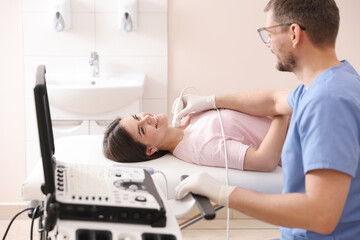 Obraz premium Sonographer conducting ultrasound examination of woman's thyroid gland in clinic