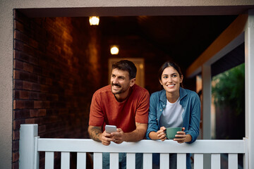 Portrait of happy couple on porch of their new home.