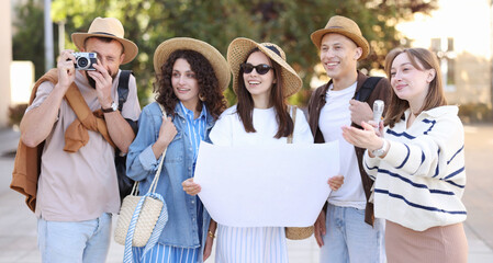 Guide with microphone and group of tourists on city street during excursion