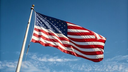 Obraz premium American flag waving on pole against clear blue sky, symbol of freedom and patriotism