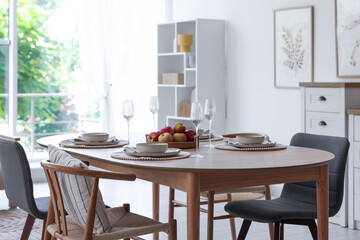 Beautiful table setting, chairs and decor in dining room. Interior design