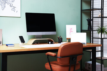Stylish workplace with modern computer, other devices and stationery on wooden desk indoors