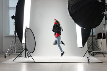 Little boy on light grey background in photo studio with professional equipment © New Africa