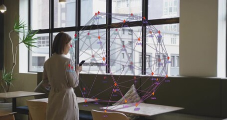 Woman lifting and swiping smartphone by window in café, animating AR technology network sphere - Powered by Adobe