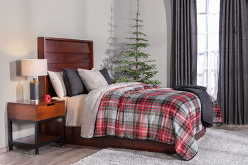 Festive bedroom styled with red tartan plaid bedding, dark wooden headboard, soft gray cushions,...