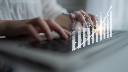 A business professional uses a laptop to analyze financial data, with hands on the keyboard and digital graphs illustrating performance trends and insights. Impute