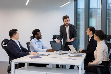 A professional business team collaborating during a presentation in a contemporary office setting, fostering teamwork and strategic discussions.