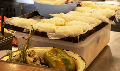 A tray of empanadas to be baked next to other food in the kitchen