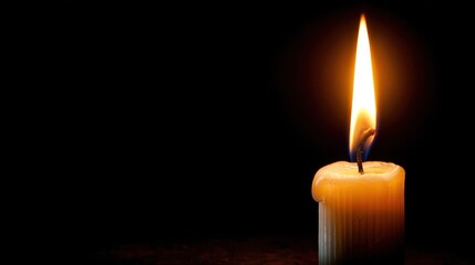 A single candle flame flickers in the darkness, creating a warm and inviting atmosphere for relaxation and reflection.