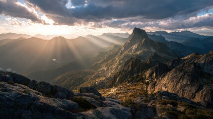 Breathtaking mountain landscape with dramatic clouds and sunlight rays illuminating the rocky terrain.