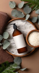 Amber bottle with blank label, rice, towel, eucalyptus sprigs on marble tray, brown background