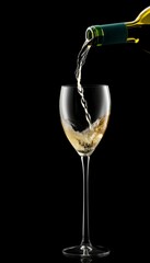 Pouring white wine into glass on black background  