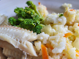 Healthy and nutritious food: fish, rice, broccoli, and carrots.