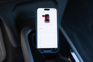 Electric car, service, open door with smart phone, safety concept. Unrecognizable automotive...